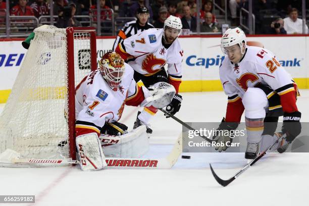 Goalie Brian Elliott of the Calgary Flames blocks a shot as TJ Brodie and Michael Stone look on against the Washington Capitals in the second period...