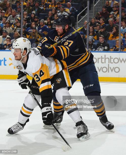 Tom Kuhnhackl of the Pittsburgh Penguins is defended by Brady Austin of the Buffalo Sabres during an NHL game at the KeyBank Center on March 21, 2017...