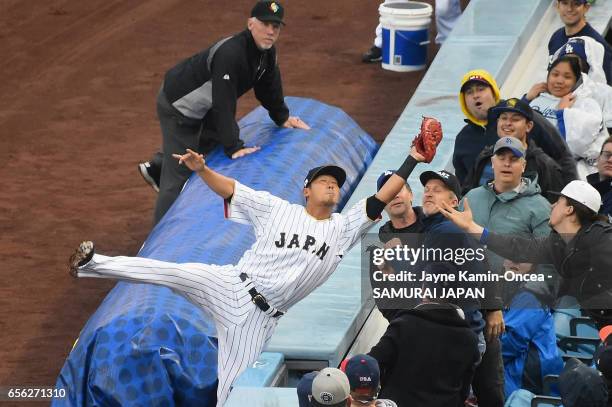 Sho Nakata of team Japan catches a pop foul hit by Nate Jones of team United States for the second out of the first inning during Game 2 of the...