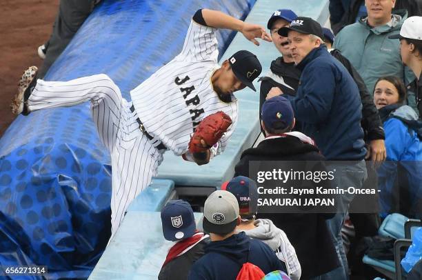 Sho Nakata of team Japan catches a pop foul hit by Nate Jones of team United States for the second out of the first inning during Game 2 of the...