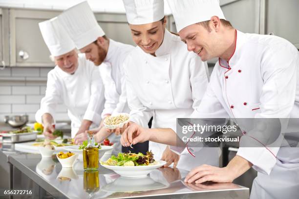 köche machen salat in der restaurantküche - cooking show stock-fotos und bilder