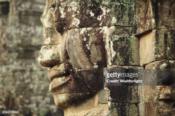 carving of a face at bayon temple - bayontempel stockfoto's en -beelden