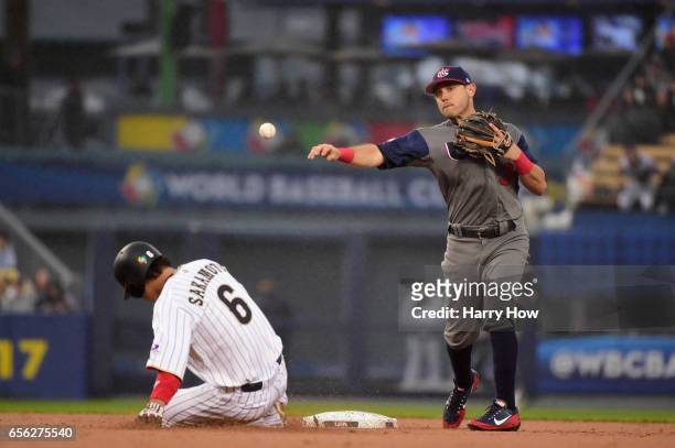 Ian Kinsler of team United States turns a double play against Hayato Sakamoto of team Japan in the second inning during Game 2 of the Championship...