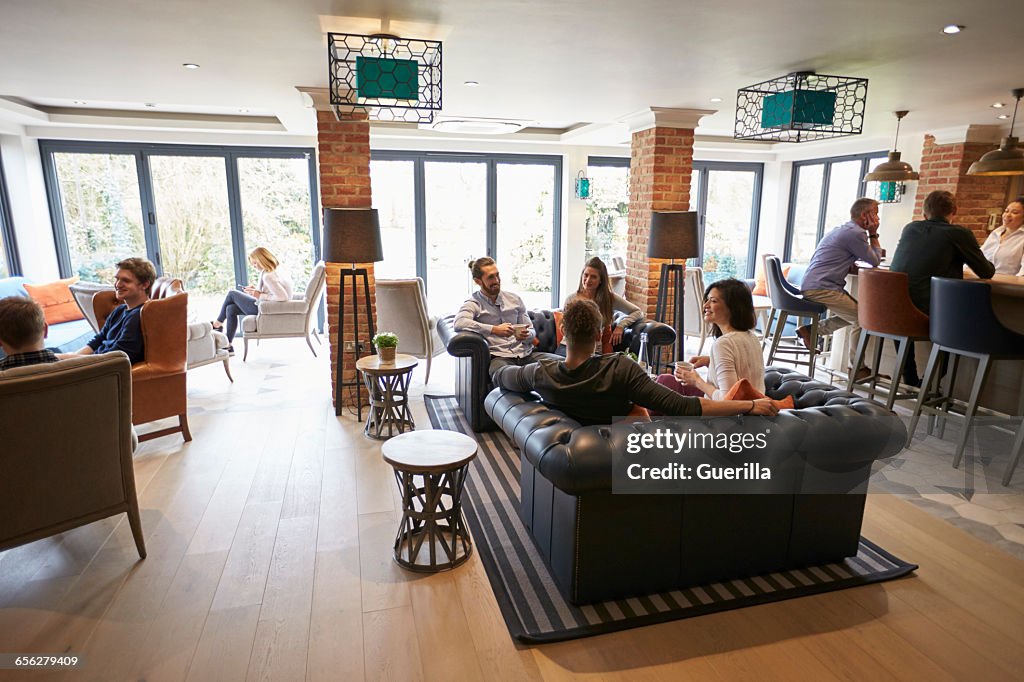 Busy Reception Area Of Modern Boutique Hotel With Guests