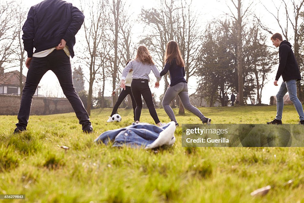 Group Of Teenagers Playing Soccer In Park Together