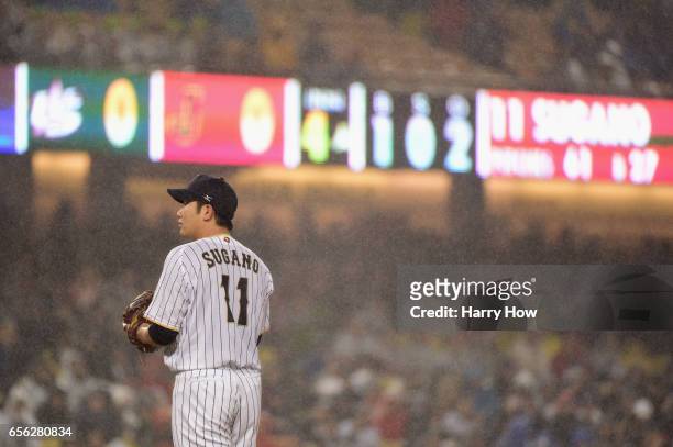 Tomoyuki Sugano of team Japan looks on in the rain during the fourth inning against team United States during Game 2 of the Championship Round of the...