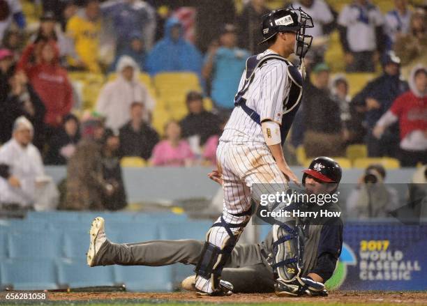 Christian Yelich of team United States slides home for 1-0 lead in the fourth inning against Seiji Kobayashi of team Japan during Game 2 of the...