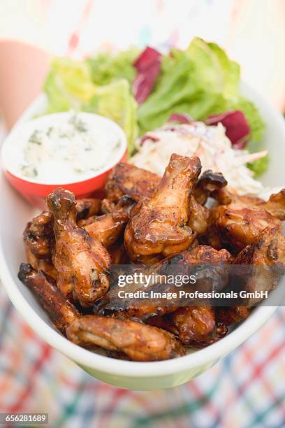 woman holding chicken wings with blue cheese dip and salad - hand chicken wing stock pictures, royalty-free photos & images