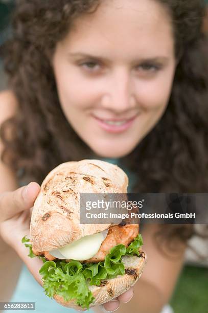 woman holding chicken burger - kipburger stockfoto's en -beelden