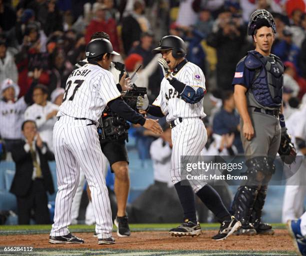 Ryosuke Kikuchi of of Team Japan celebrates with teammates after hitting a solo home run in the sixth inning of Game 2 of the Championship Round of...