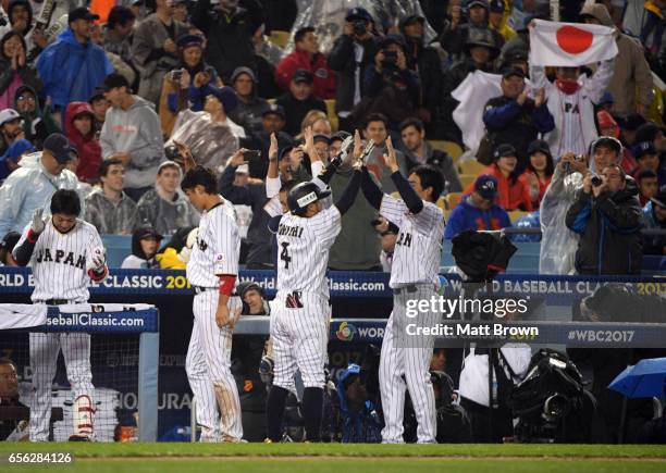 Ryosuke Kikuchi of of Team Japan celebrates with teammates after hitting a solo home run in the sixth inning of Game 2 of the Championship Round of...
