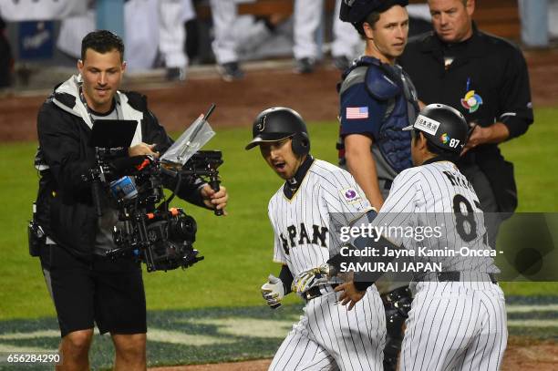 Ryosuke Kikuchi of team Japan celebrates his game-tying home run with coach Toshihisa Nishi in the sixth inning against team United States during...