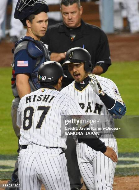 Ryosuke Kikuchi of team Japan celebrates his game-tying home run with coach Toshihisa Nishi in the sixth inning against team United States during...