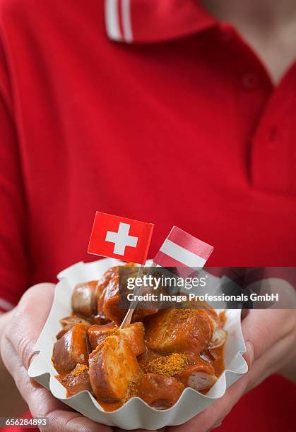 woman holding currywurst with two flags in paper dish - fat soccer players stock pictures, royalty-free photos & images