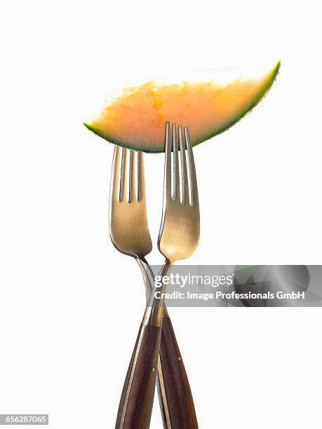 two forks with slice of melon - honeydew melon isolated stock pictures, royalty-free photos & images