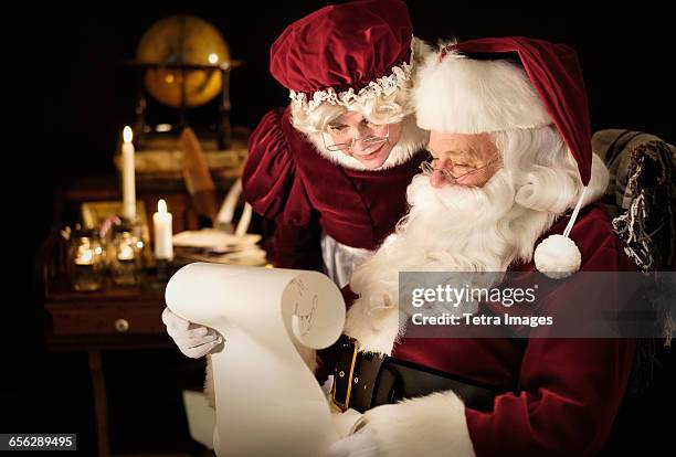 santa and mrs. claus reading childs letter - mãe natal imagens e fotografias de stock