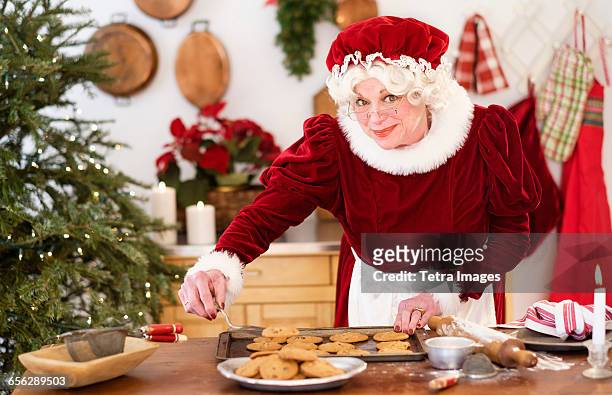 mrs. claus making gingerbread cookies - mrs claus stock pictures, royalty-free photos & images