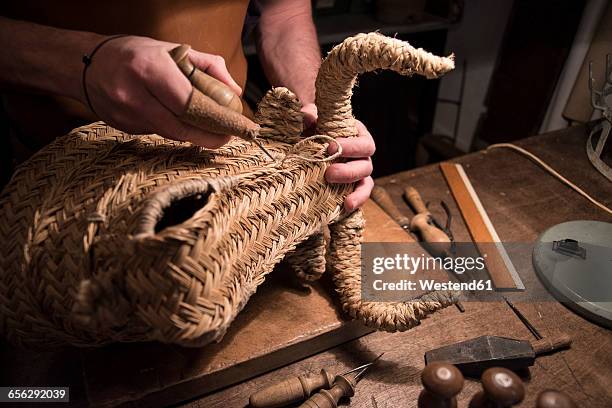 artisan braiding a wicker bull's head in his workshop - wicker stock pictures, royalty-free photos & images