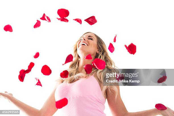 young woman throwing up rose petals above head - throwing flowers stock pictures, royalty-free photos & images