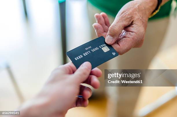 close-up of two hands with credit card - handing over credit card stock pictures, royalty-free photos & images