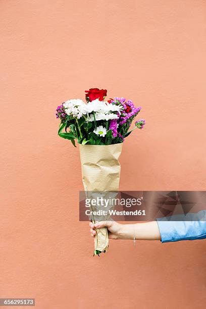 woman holding bunch of flowers - man giving flowers stock-fotos und bilder