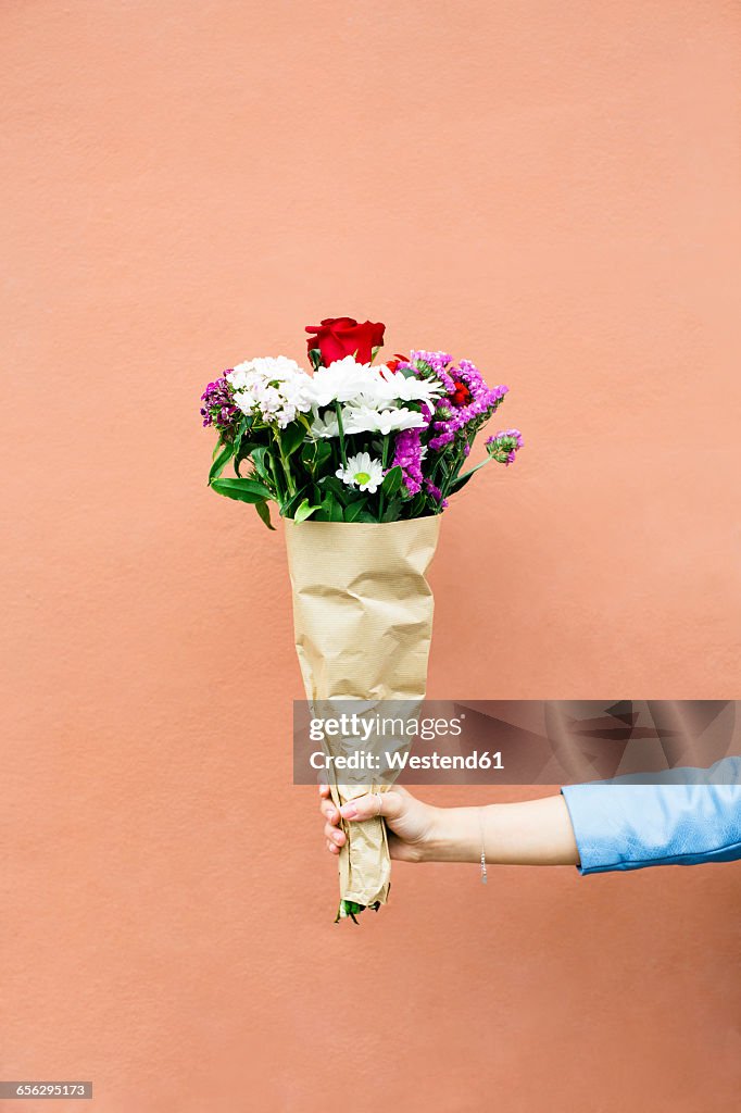 Woman holding bunch of flowers