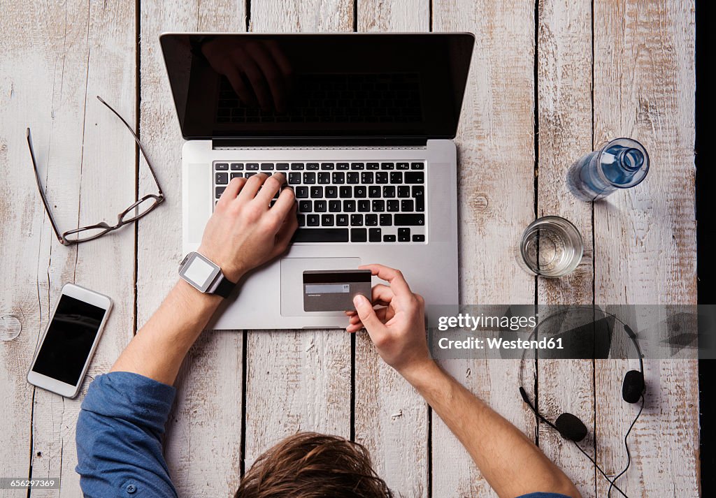 Man sitting at desk paying online with credit card