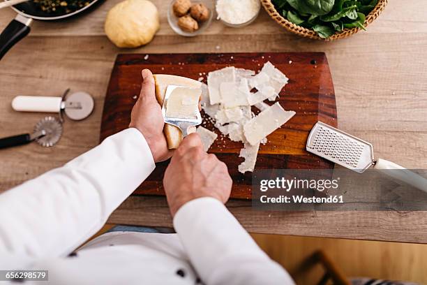 chef preparing stuffing for ravioli, slicing parmesan cheese - parmesan stock-fotos und bilder