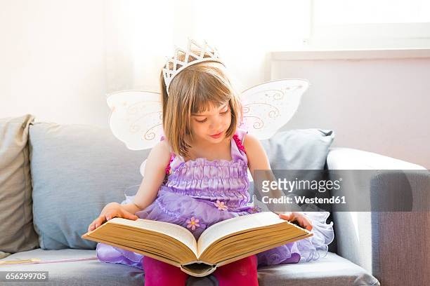portrait of little girl dressed up as fairy queen reading book - the fairy queen stock pictures, royalty-free photos & images