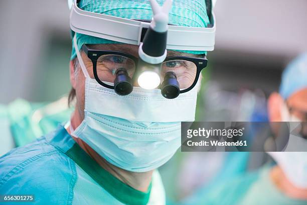 portrait of heart surgeon with headlamp - heart surgery stock pictures, royalty-free photos & images