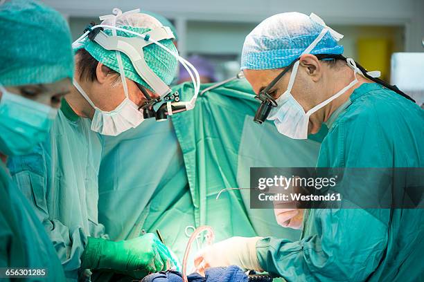 heart surgeons during a heart operation - herzoperation stock-fotos und bilder