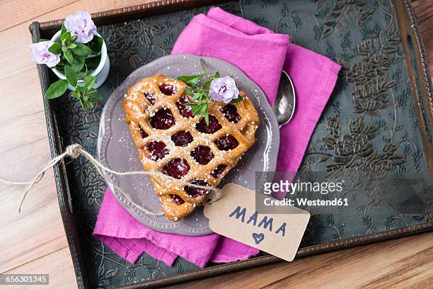 heart-shaped cherry cake with name tag and flowers on tray - muttertag stock-fotos und bilder