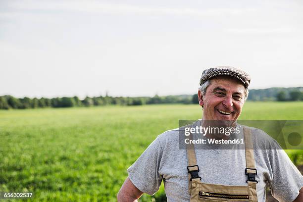 portrait of smiling farmer at a field - farmer portrait stock pictures, royalty-free photos & images