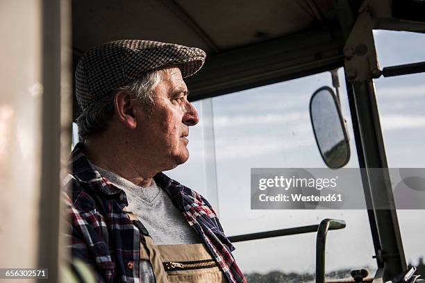 portrait of farmer on tractor - farmer portrait stock-fotos und bilder