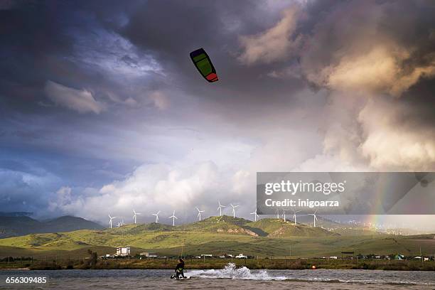 man kite surfing at los lances lagoon, tarifa, andalucia, spain - kite lagoon stock-fotos und bilder