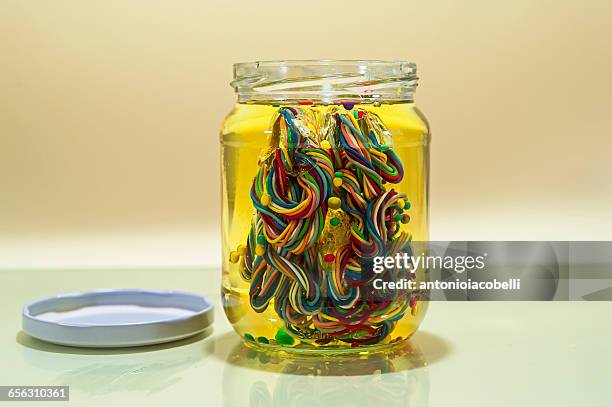 conceptual brain in glass jar of oil made from multi-colored wires - brain in a jar stock pictures, royalty-free photos & images