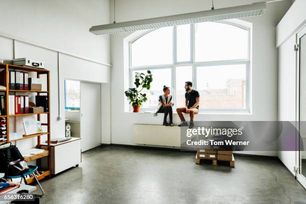 young start up business people sitting in a window and talking - big hug stock pictures, royalty-free photos & images