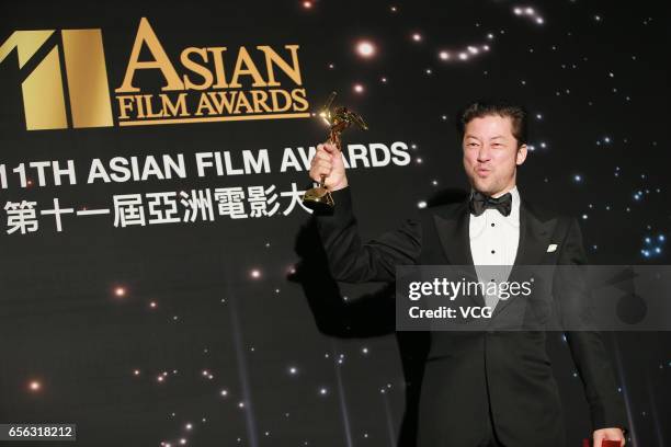 Japanese actor and musician Tadanobu Asano, winner of the Best Actor award for film 'Harmonium', celebrates at the backstage of the 11th Asian Film...