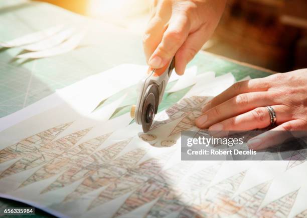 close up of globe maker's hands cutting map gores - cartographer stockfoto's en -beelden