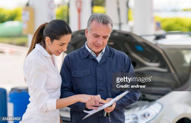 mujer hablando con un mecánico de su coche - car insurance fotografías e imágenes de stock