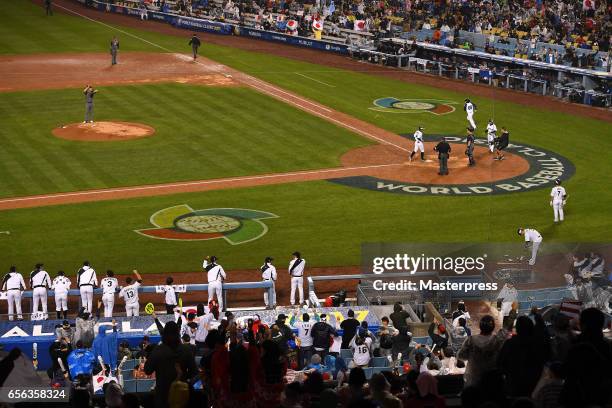 Ryosuke Kikuchi of Japan rounds the bases after a game-tying home run with teammates in the six inning during the Game 2 of the Championship Round of...