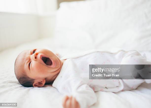 baby girl yawning on bed - baby sleep imagens e fotografias de stock