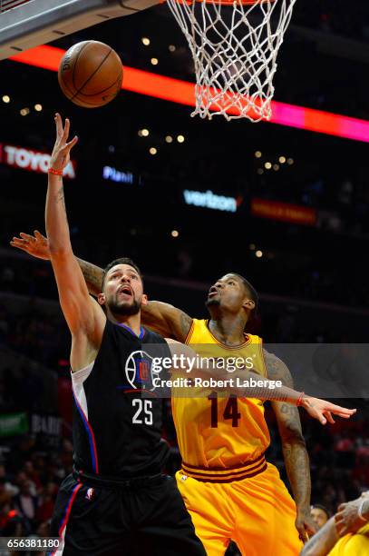 Austin Rivers of the Los Angeles Clippers attempts a lay up against DeAndre Liggins of the Cleveland Cavaliers on March 18, 2017 at STAPLES Center in...