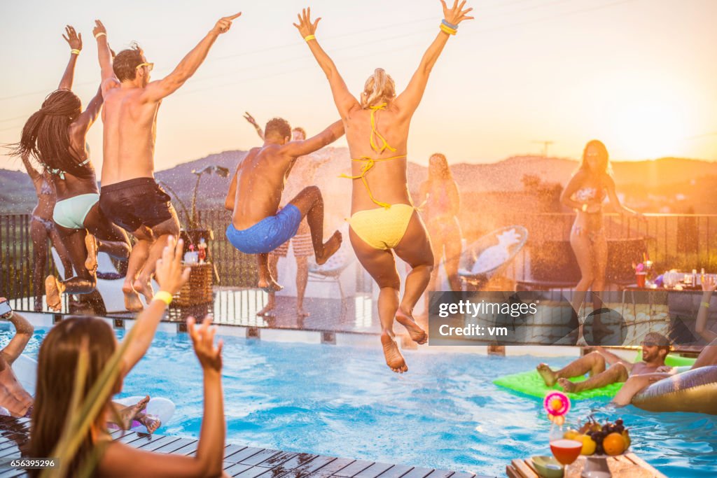 Party people jumping in the pool