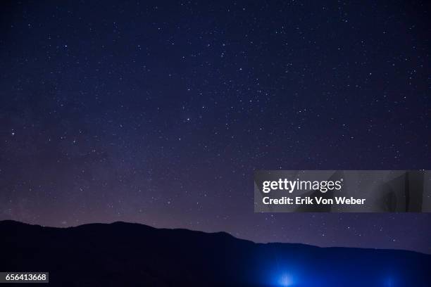 hillside at night with stars - cielo fotografías e imágenes de stock