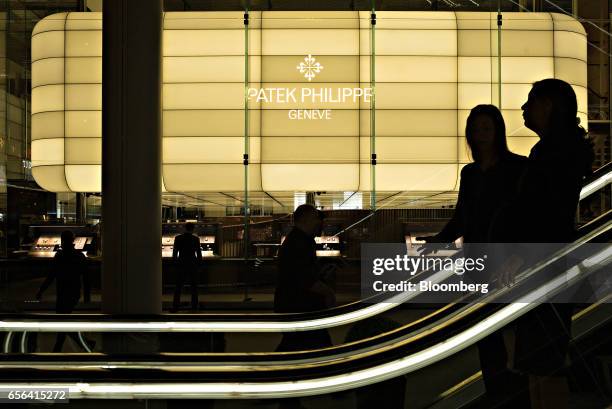 Patek Philippe SA sign stands on display as visitors ride an escalator during the 2017 Baselworld luxury watch and jewellery fair in Basel,...