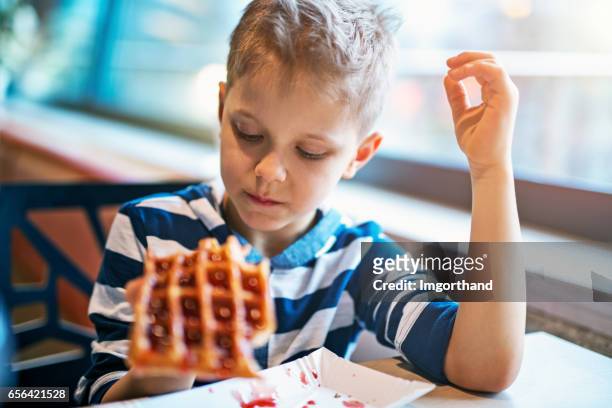 little boy eating waffle with jam - waffle stock pictures, royalty-free photos & images