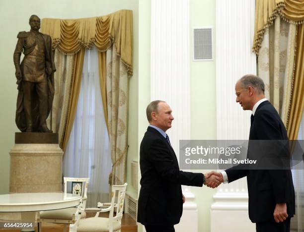 Russian President Vladimir Putin greets CEO and President of BASF, german businessman Kurt Bock during their meeting at the Kremlin, on March 22,...