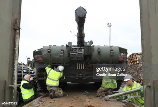 Crew secures a British Army Challenger 2 tank of the 5th Battalion The Rifles to a truck trailer after the tank and other heavy vehicles arrived by...