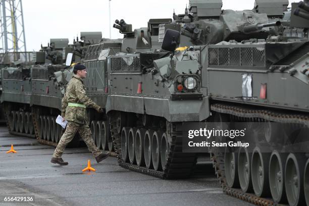 British Army soldier walks past Warrior tanks of the 5th Battalion The Rifles after the tanks and other heavy vehicles arrived by ship on March 22,...